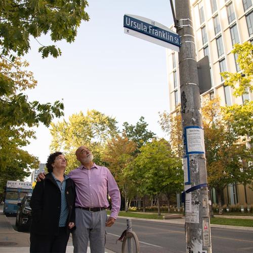 Siblings Monica and Martin Franklin look up at a sign on a light pole that reads: Ursula Franklin St.