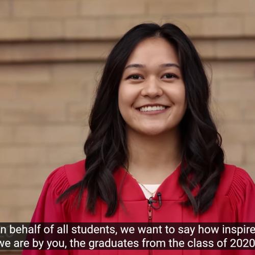 A student in academic robes smiles as she congratulates U of T's Fall 2020 graduates.