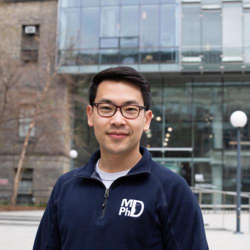 Ben Ouyang smiling and wearing his MD/PhD hoodie.