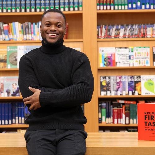 Michael Gayle smiling and standing in front of bookshelves