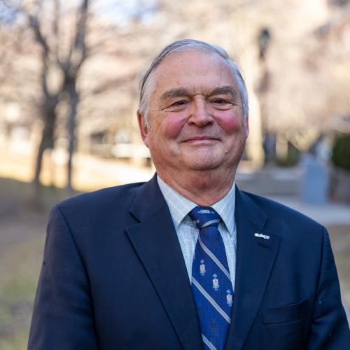 A portrait of a person wearing a blue business suit and tie. 