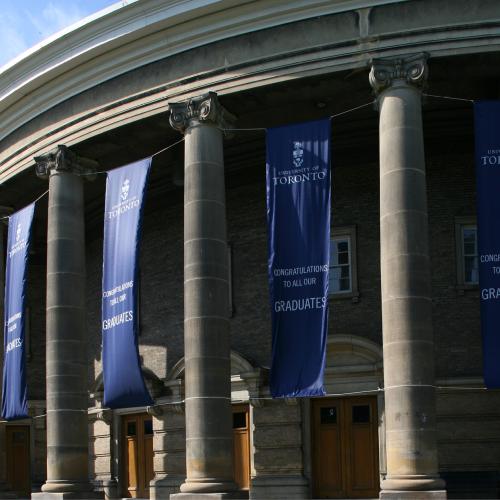 Banners hang on the pillars outside Convocation Hall. They read: Congratulations to all our graduates, University of Toronto.