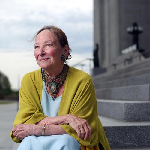 Rosalie Abella smiles, sitting on the steps of the Canadian supreme court.