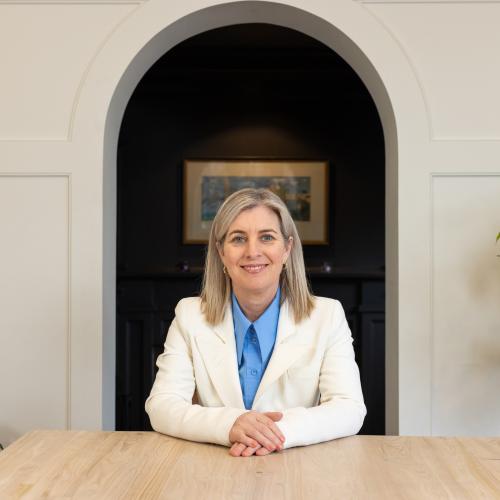 Melanie Woodin smiles while sitting behind a desk.