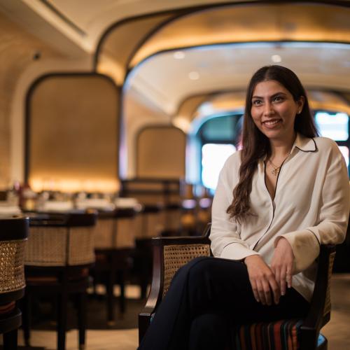 Ambica Jain sits in her restaurant Adrak Yorkville, smiling.