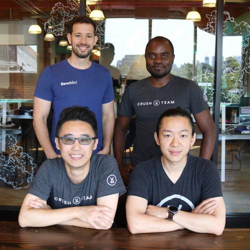 BenchSci co-founders and U of T alumni Liran Belenzon, Elvis Wianda, David Chen and Tom Leung, standing in a busy office.