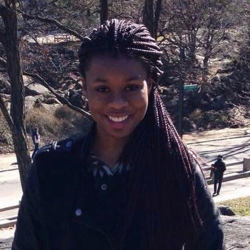 Chelsea Chioma Anthony smiling. She is standing in a park overlooking a road.