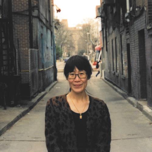 Christina Wong standing in a quiet alleyway.