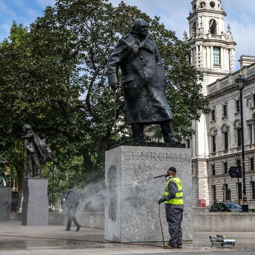 A worker uses a power hose to clean graffiti from the base of a statue of Sir Winston Churchill in London, U.K.