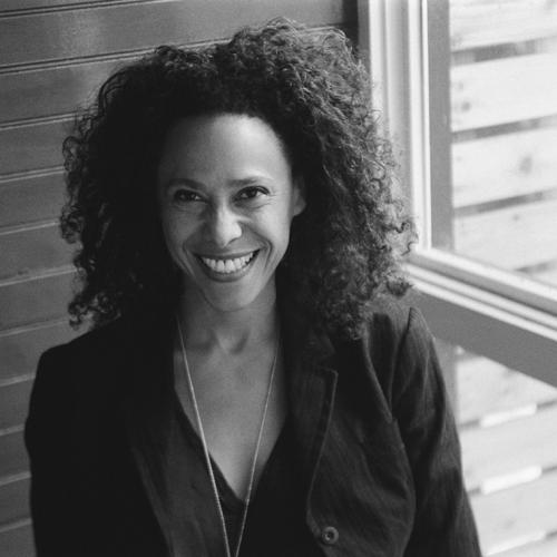 Photo of Beth Coleman smiling by a window.