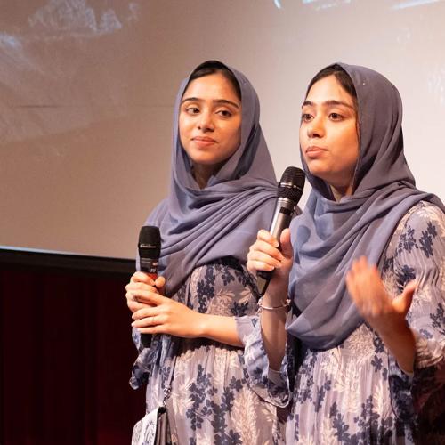 Nivaal and Maryam Rehman stand on stage, holding microphones