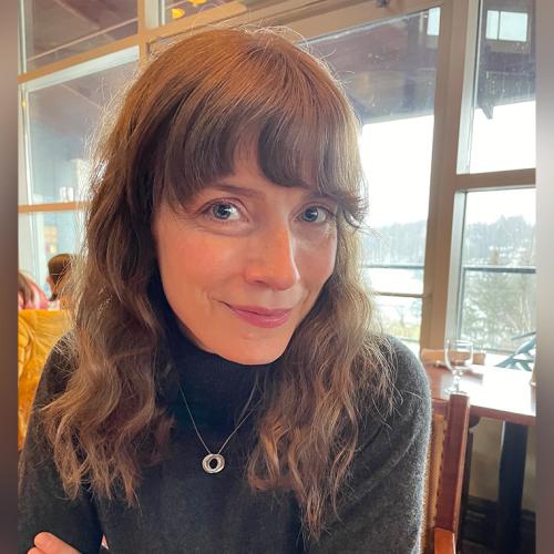 Elizabeth Kalbfleisch smiles as she sits in a cafe.