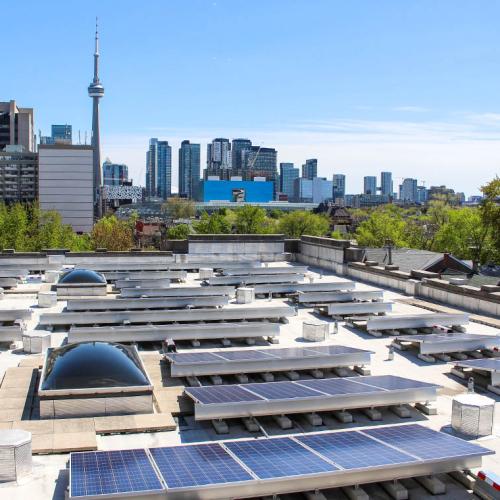 A rooftop at U of T is dotted with solar panel installations, angled to face south.