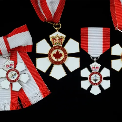 Order of Canada medals on a black surface