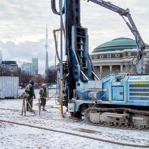 A crane drills a borehole on snow-covered Front Campus for thermal performance testing.
