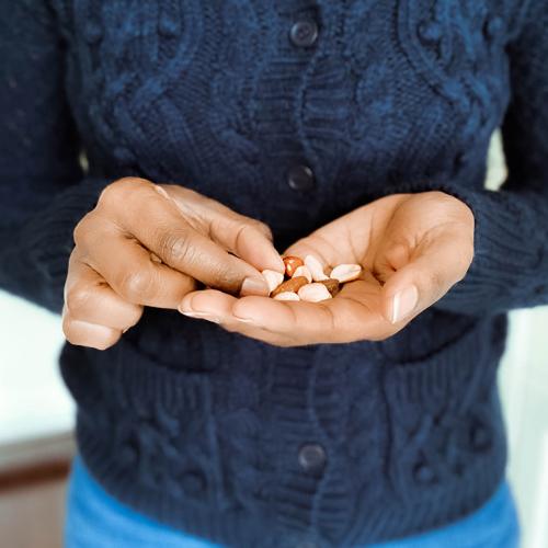 A woman picks out an almond from a handful in her palm.