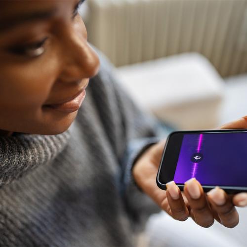 A young woman speaking into a smartphone.