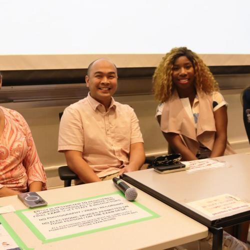 A panel of four people sitting at a desk