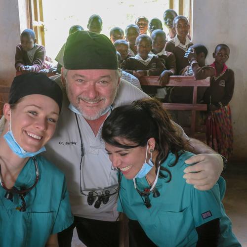 Courtney David, Elahe Behrooz and Izchak Barzilay smile with kids in Kabale, Uganda.