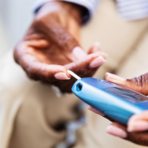 A person's hands hold a small rounded device with a tongue sticking out of it and resting on one fingertip.