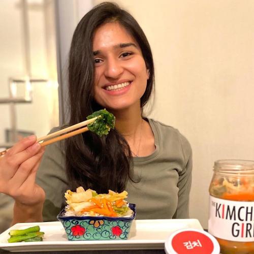 Meraj Ellahi sitting at a table and eating with chopsticks