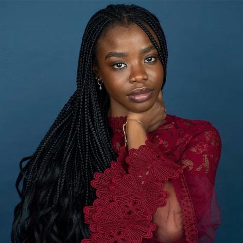 Portrait of Kudakwashe Rutendo in a burgundy lace dress