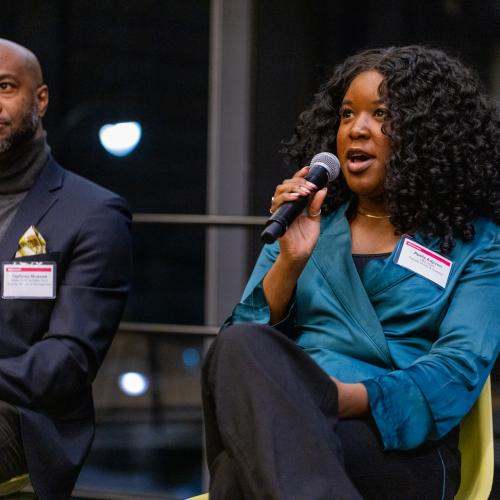 Two panelists speaking on stage