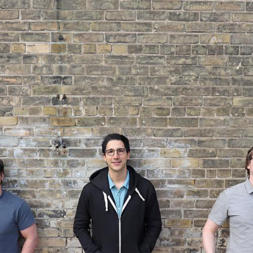 Chris Leichthammer, Aidan Tinafar and Alex Klenov smile as they pose in front of a brick wall.