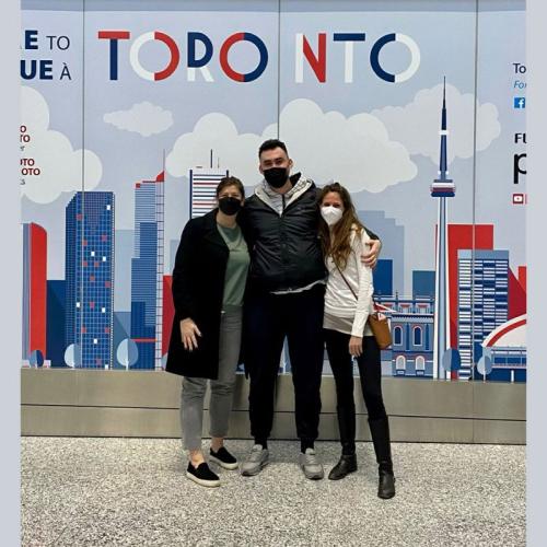 Dana Wagner and friends pose for a picture in front of a mural of the Toronto skyline.