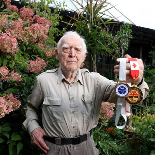 A man standing outside and holding medals