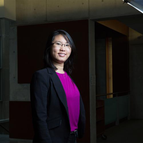Philiz Goh smiles, standing in the lobby of a building.