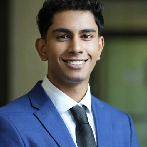 A portrait of Roshawn smiling in a smart blue suit