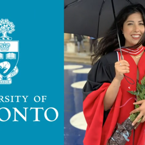Sanamtha Yammine smiles, wearing academic robes and holding flowers and an umbrella.