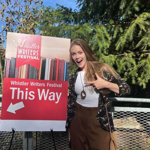 Shannon Terrell pointing to a sign at the Whistler Writer's Festival