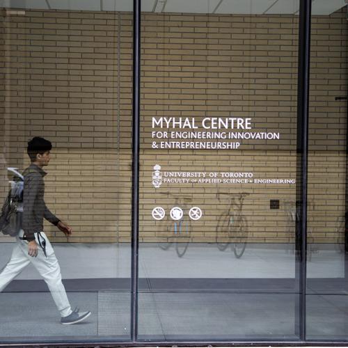 A young man with a backpack walks through the atrium of the Myhal Centre for Engineering Innovation & Entrepreneurship.