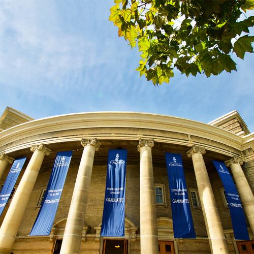 A photo looking up at Convocation Hall. The building is hung with banners that say, Congratulations to all our graduates.