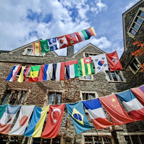 Rows of flags from dozens of countries hang from cords in the quadrangle of Victoria College residence.