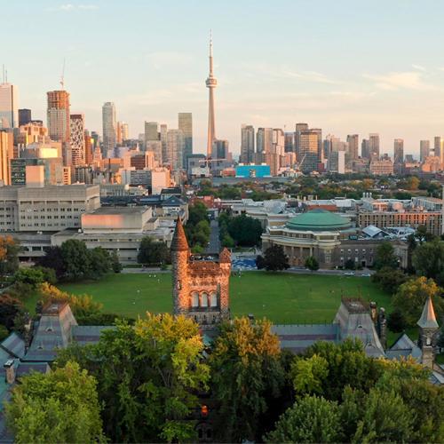 In an aerial view, the tower of University College glows in the sunset above downtown Toronto.