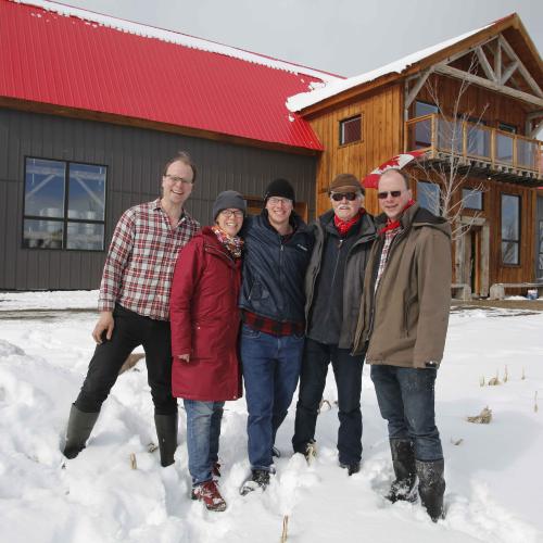 The Tomory family in front of their red-roofed barn at Pefferlaw Creek Farms