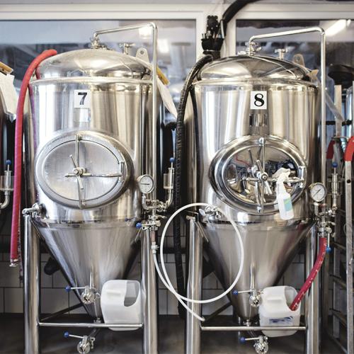 Metal brewing vats look like giant coffee dispensers linked by tubing and industrial gauges.
