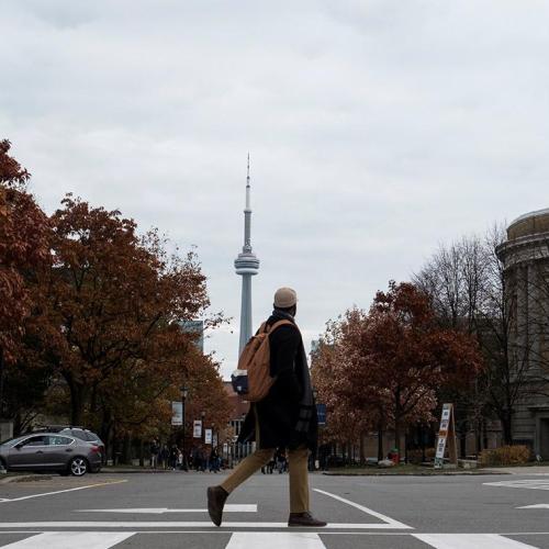 Student crossing Convocation Plaza in front of the CN Tower. Photo by Laura Pederse