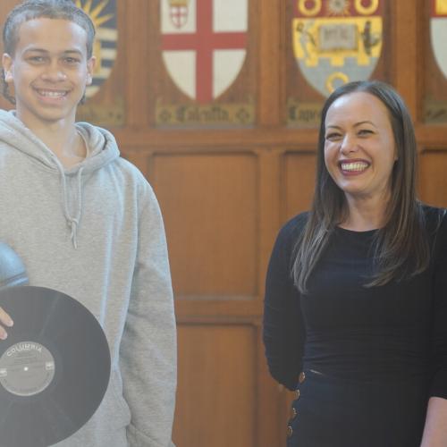 Danielle Dinunzio stands next to a male student in Hart House, both smiling.