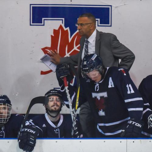 Darren Lowe and several hockey players on the bench