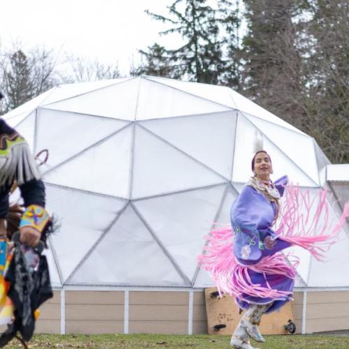 Indigenous dancers performing in front of a white dome