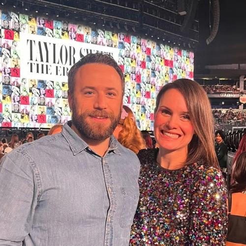 David Lawrence and his wife smiling in front of Taylor Swift's stage