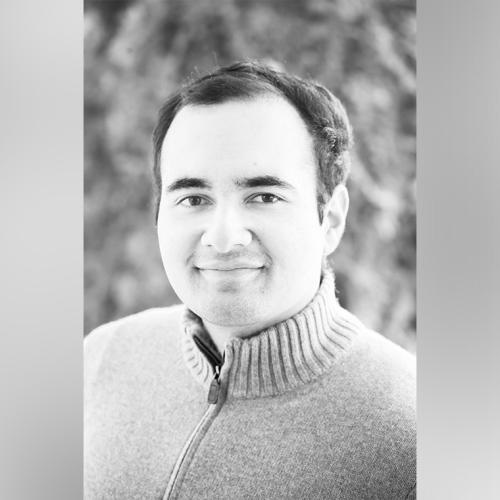 A black and white portrait of Mohammad Asadi-Lari smiling.