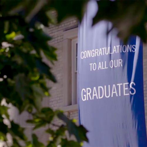 A banner saying Congratulations to all our Graduates hangs outside Convocation Hall.