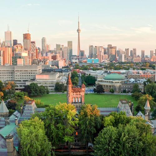 In an aerial shot, Front Campus and University College glow in sunset light. Downtown Toronto stretches behind them.