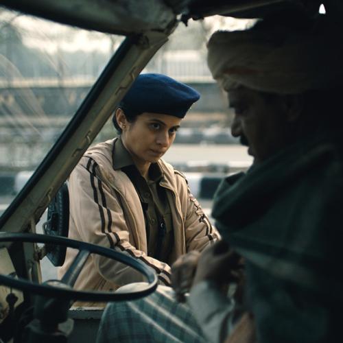 A woman in uniform looks doubtful as she peers through a bus window at a bus driver sitting in his driving seat.