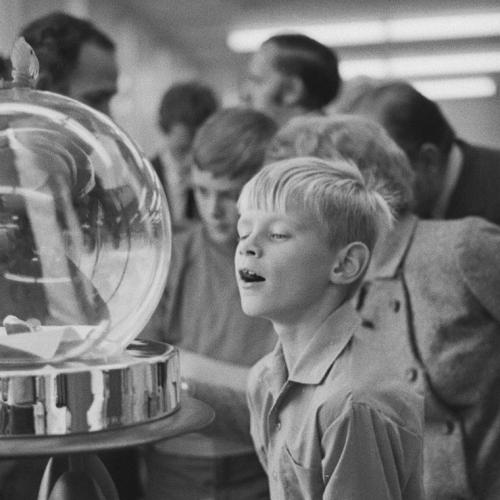 A young boy stares open-mouthed at moon rocks displayed  under a glass bubble.
